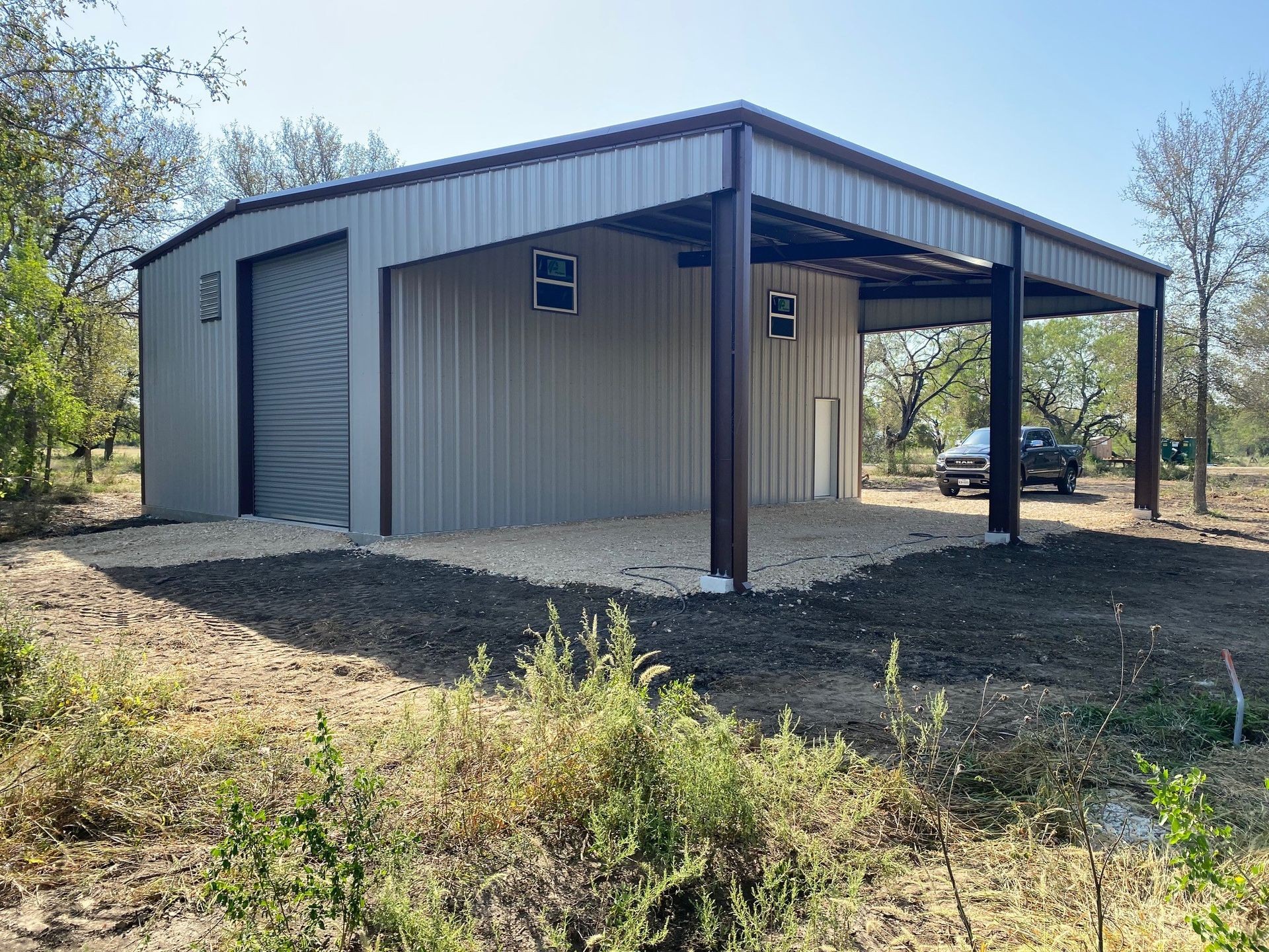 Detached metal garage with roll-up door and side entry, built on rural Texas property Detached metal garage with roll-up door and side entry, built on rural Texas property
