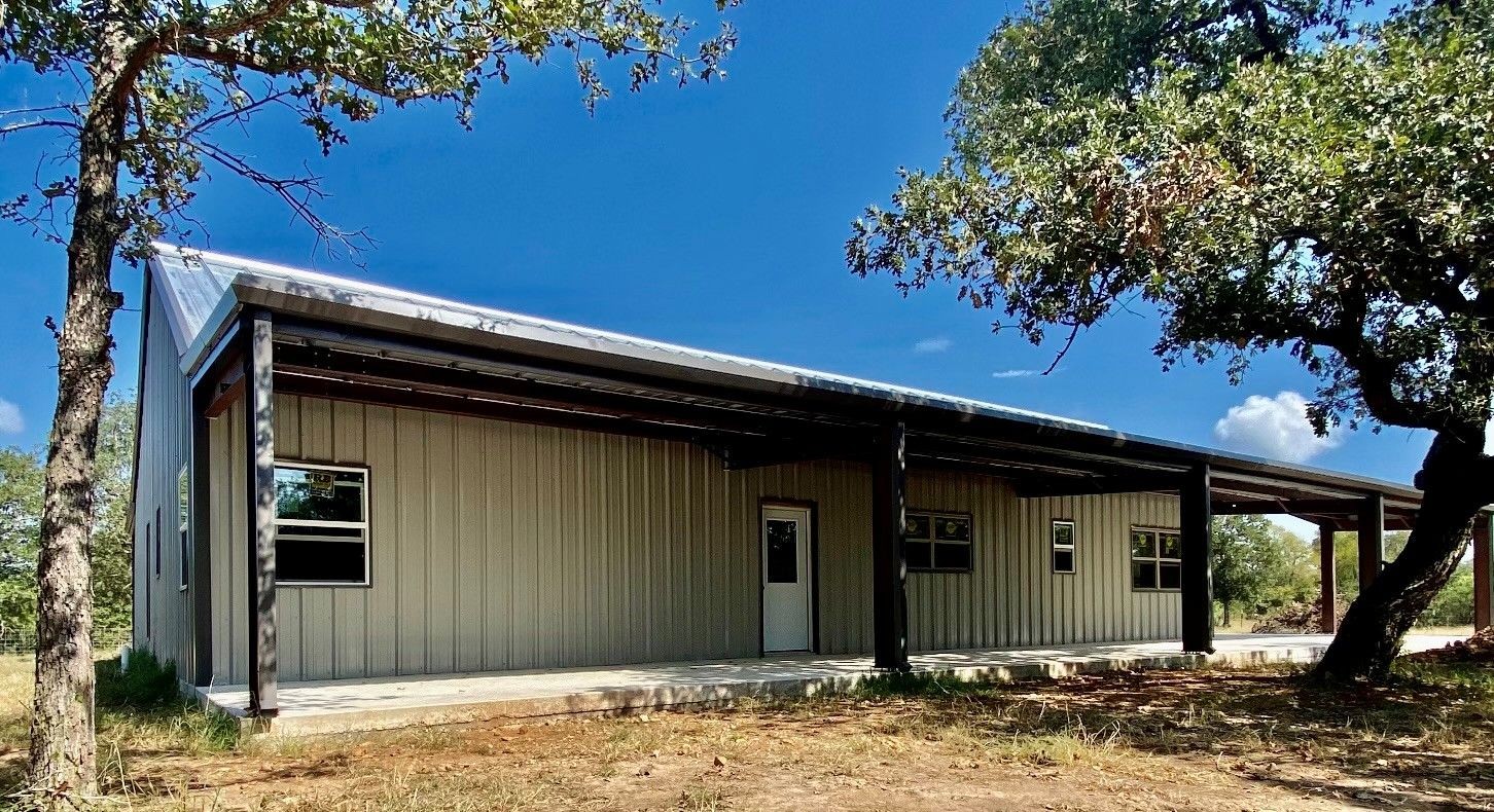 Steel barndominium home with covered porch under clear Texas sky Steel barndominium home with covered porch under clear Texas sky