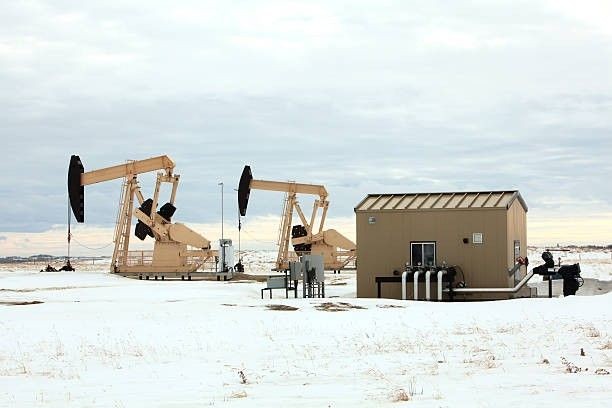 Pre-engineered steel buildings and pump jacks at an oilfield site in Texas with snow-covered ground, showcasing rugged infrastructure for energy sector use. Pre-engineered steel buildings and pump jacks at an oilfield site in Texas with snow-covered ground, showcasing rugged infrastructure for energy sector use.