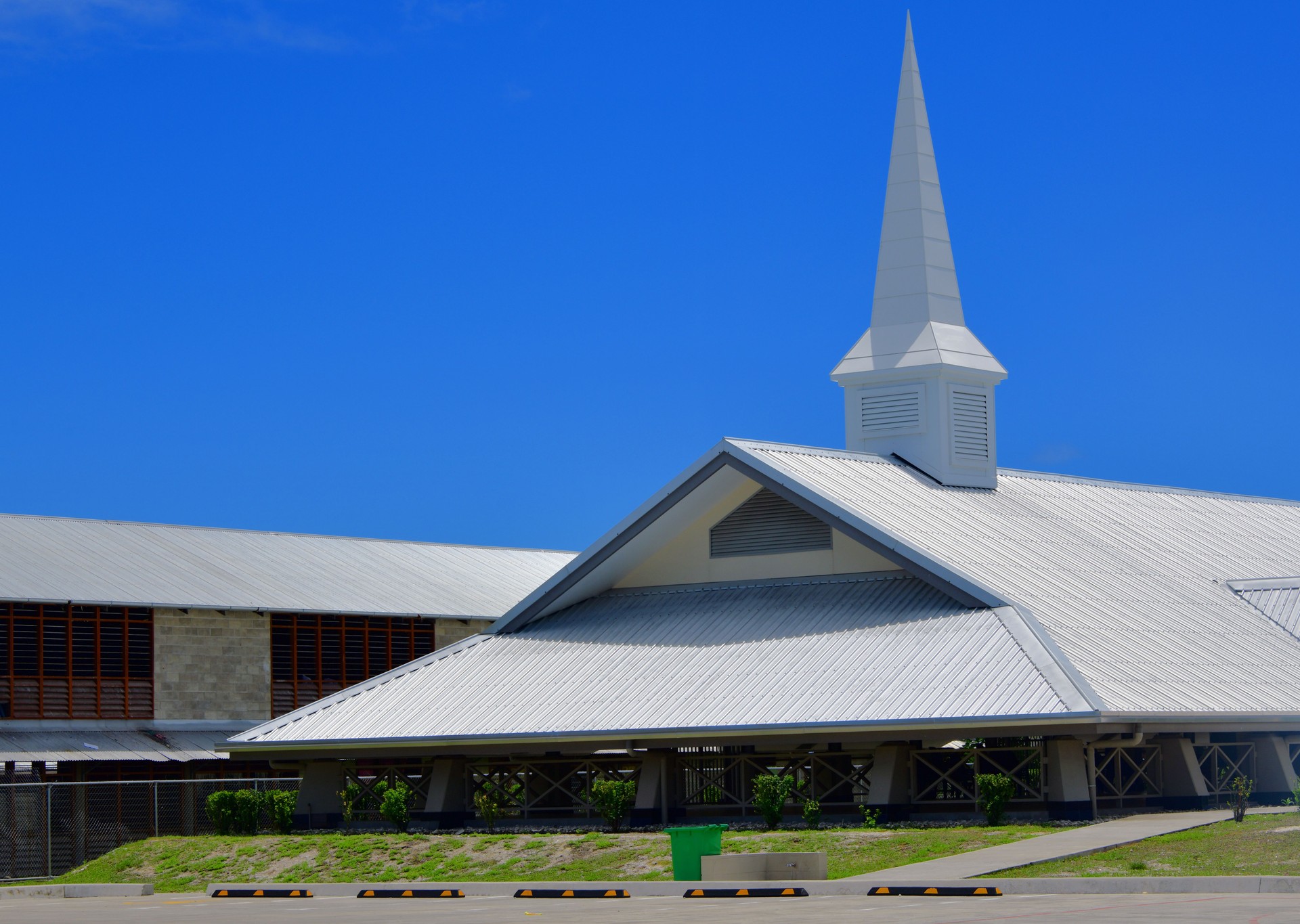 Steel church building with white roof and steeple under blue sky Steel church building with white roof and steeple under blue sky